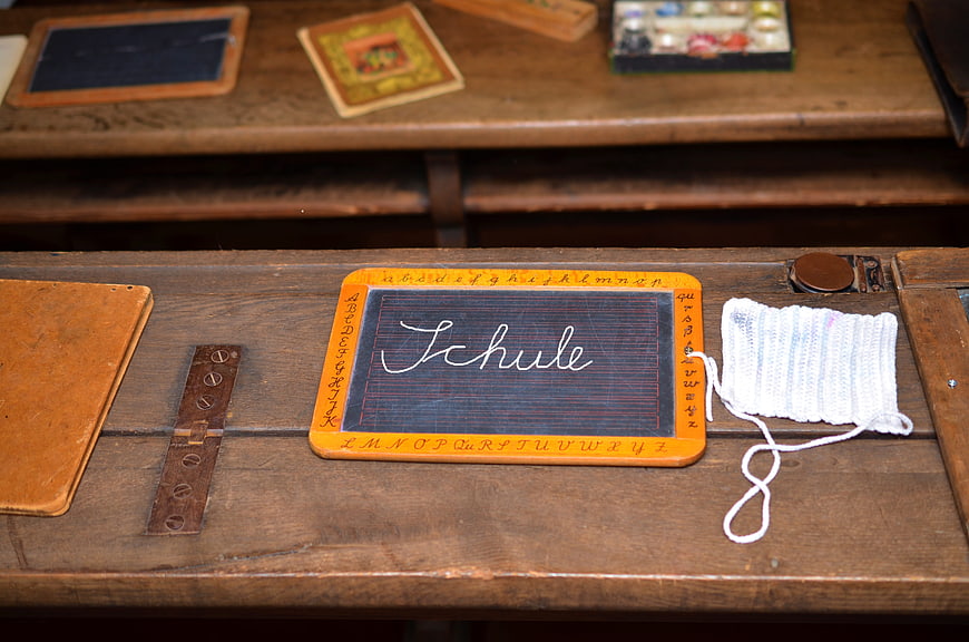 Vintage wooden school desk with slate blackboard and knitting