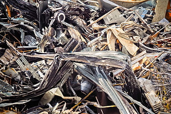 Pile of crushed scrap metal and industrial waste in a recycling yard