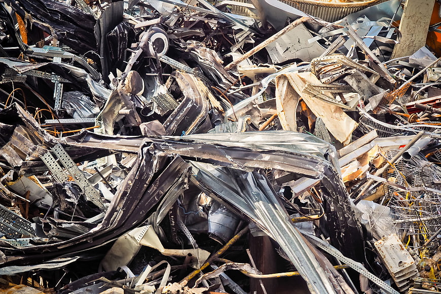 Pile of crushed scrap metal and industrial waste in a recycling yard