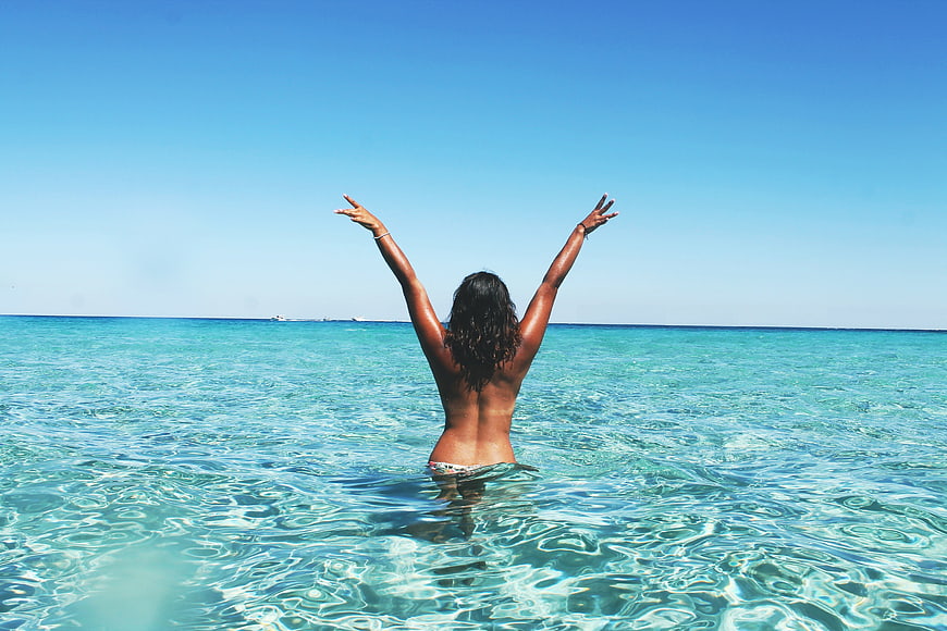 Woman Celebrating Freedom in Crystal Clear Tropical Ocean Water