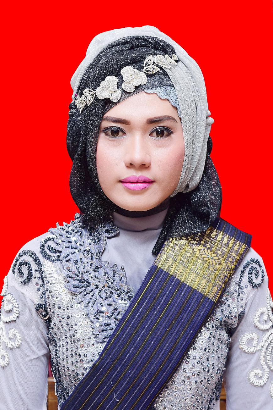 Woman in Traditional Silver and Blue Attire with Hijab