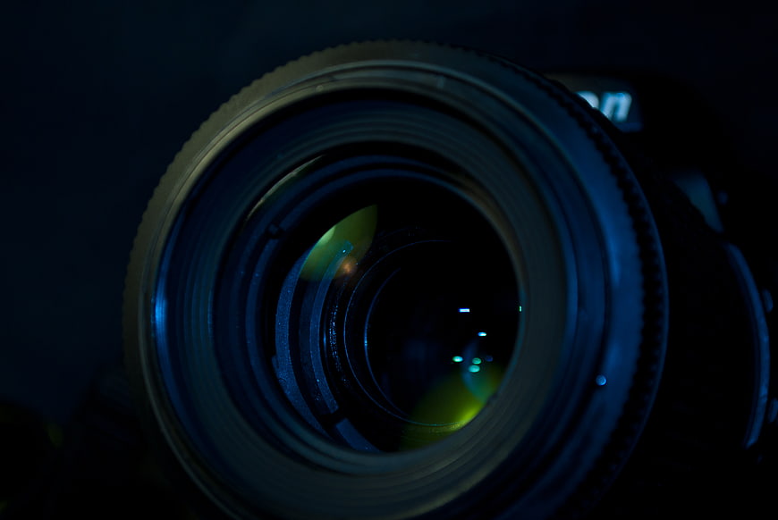 Close-up of DSLR Camera Lens with Blue and Green Reflections