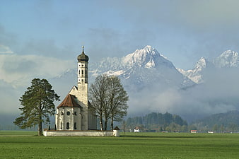 St. Coloman Church in Schwangau with Snow-Capped Alps and Misty Landscape