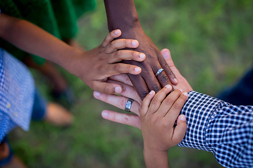Diverse family hands stacked together in unity and support