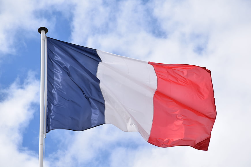 French Tricolor Flag Waving Against Blue Sky