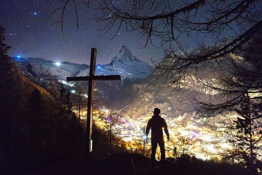 Silhouette of Man and Cross Overlooking Zermatt at Night