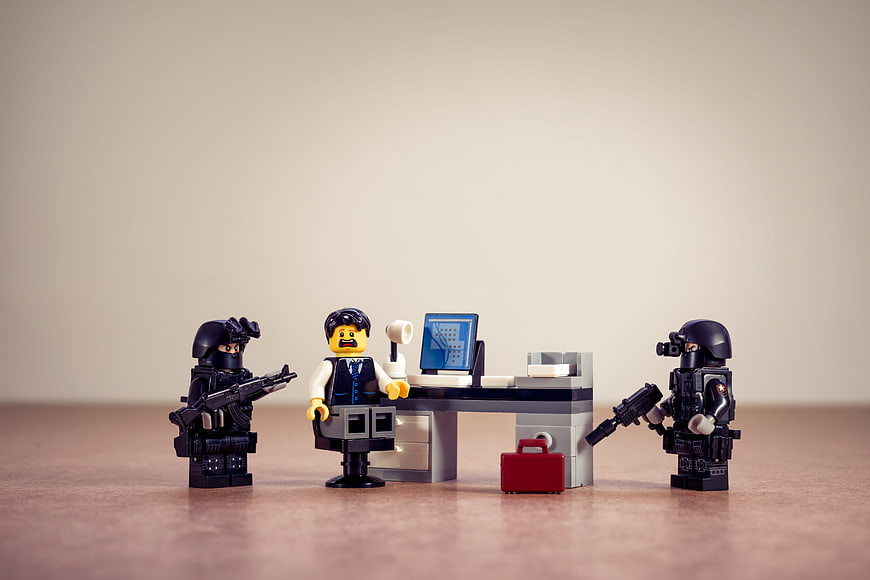 Lego SWAT team arresting businessman at office desk