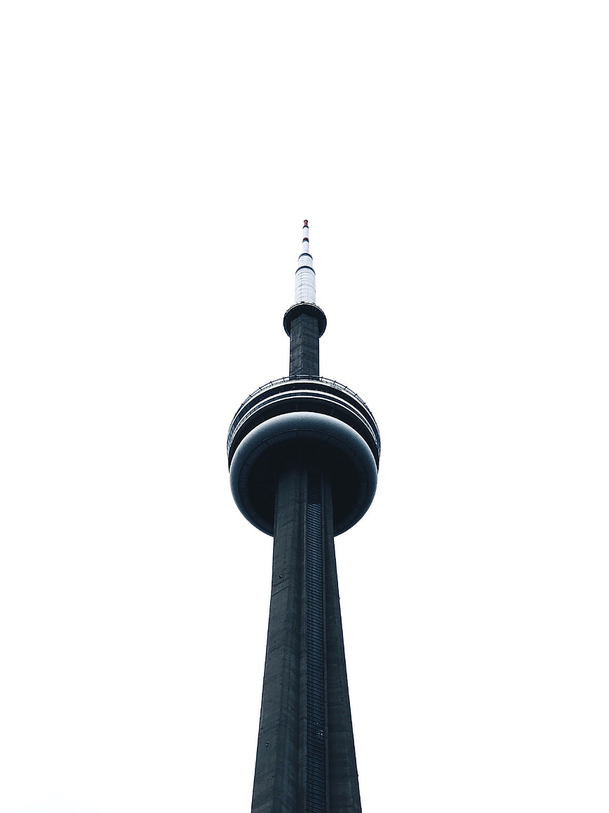 Low angle view of tall concrete tower against white sky