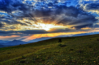 Dramatic Sunset Over Green Mountain Plateau With Sunbeams