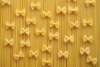 Farfalle pasta on spaghetti background flat lay