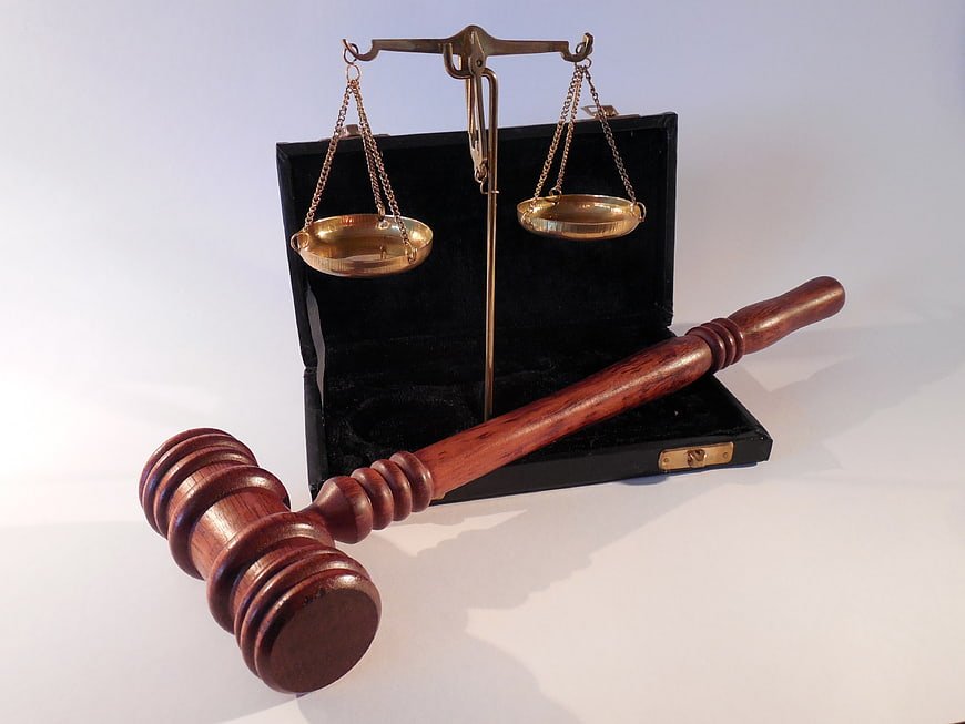 Wooden Gavel and Brass Scales of Justice on White Background