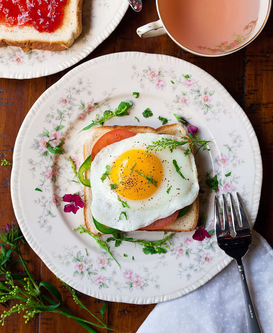 Overhead view of fried egg sandwich on vintage floral plate