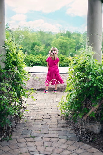 Little Girl in Pink Dress Looking at Green Landscape