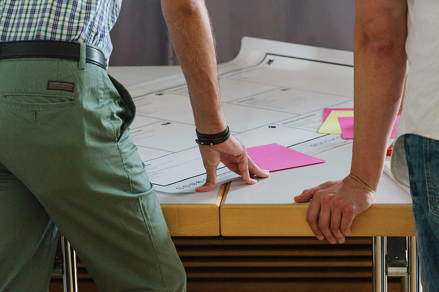 Team brainstorming session with sticky notes and documents