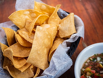 Basket of Tortilla Chips with Salsa on Wooden Table