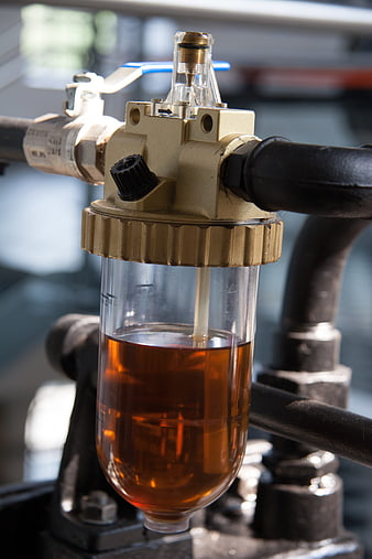 Close-up of industrial oil filter with amber liquid