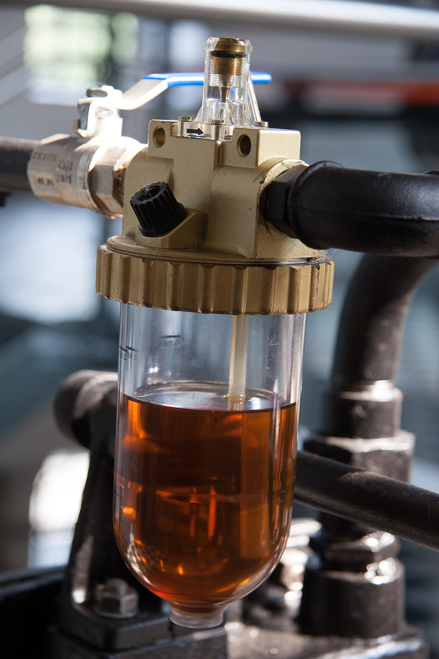 Close-up of industrial oil filter with amber liquid