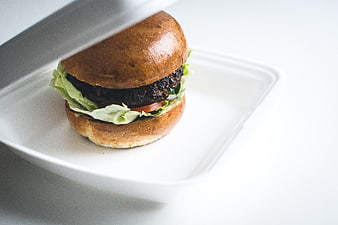 Beef burger in white takeaway container on white background