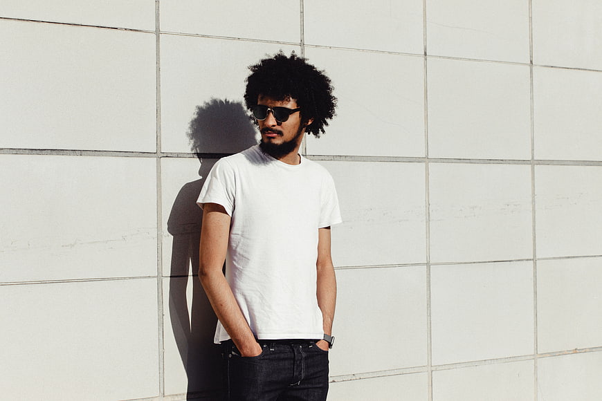 Man with Afro and Sunglasses Against White Wall