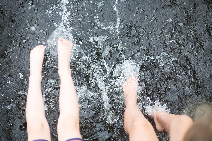 Children's Feet Splashing in Dark Water