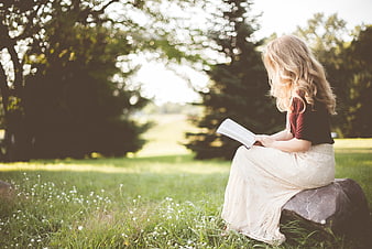 Girl Reading Book in Sunlit Park
