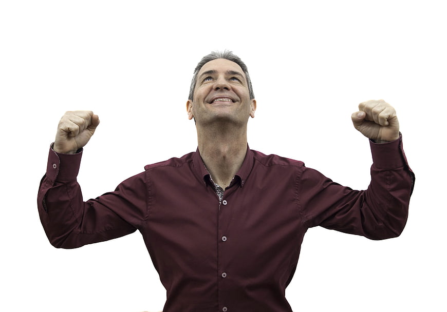 Happy mature man celebrating success with raised fists