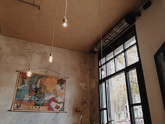 Vintage map on concrete wall with hanging Edison bulbs