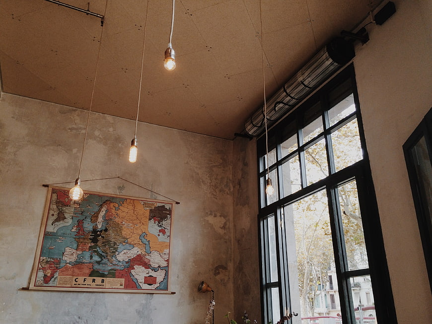 Vintage map on concrete wall with hanging Edison bulbs