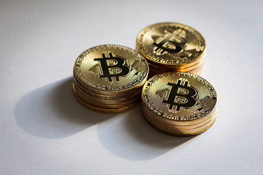 Stacks of Gold Bitcoin Coins on White Background