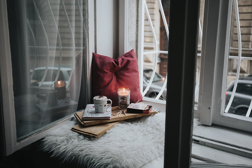 Cozy Window Seat with Hot Chocolate, Candle, and Books