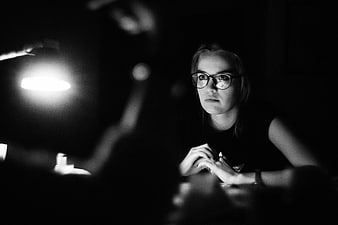 Woman with glasses working late at night in dark room