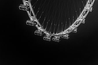 Black and white ferris wheel detail against dark background
