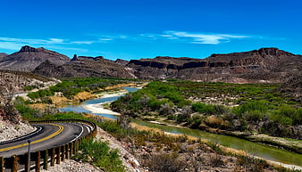Winding Desert Road Along River with Red Rock Mountains
