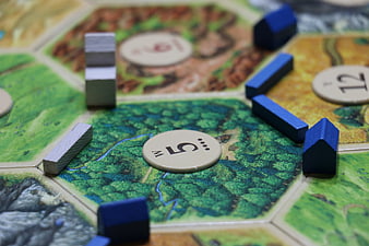 Close-up of Settlers of Catan board game pieces and tiles