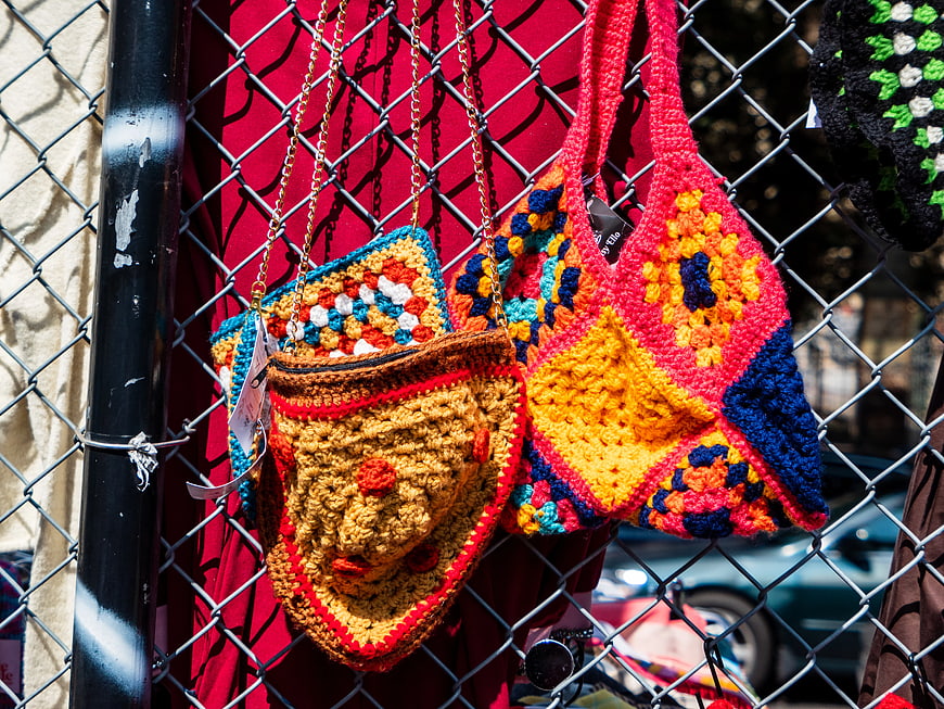 Colorful Crochet Bags Hanging on Chain Link Fence