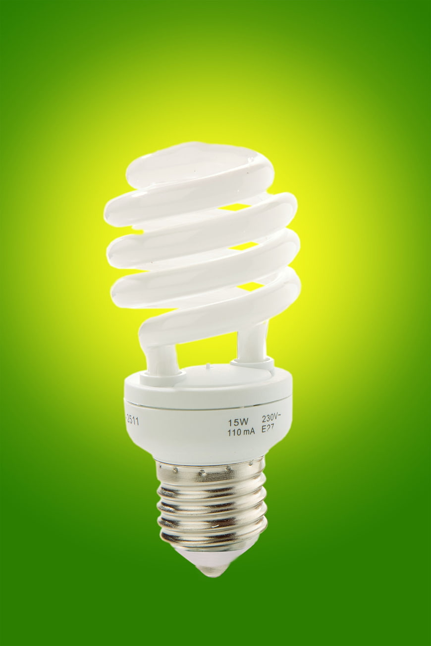 Compact Fluorescent Energy Saving Light Bulb On Green Background