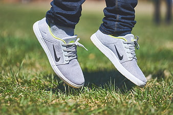 Gray Nike Sneakers Jumping on Green Grass