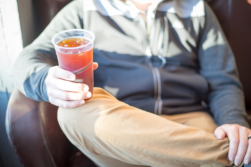 Man Holding Iced Tea in Plastic Cup