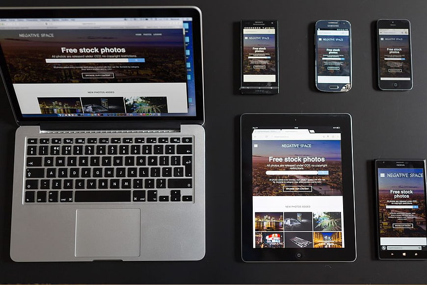 Flat lay of laptop, tablet, and smartphones displaying responsive website