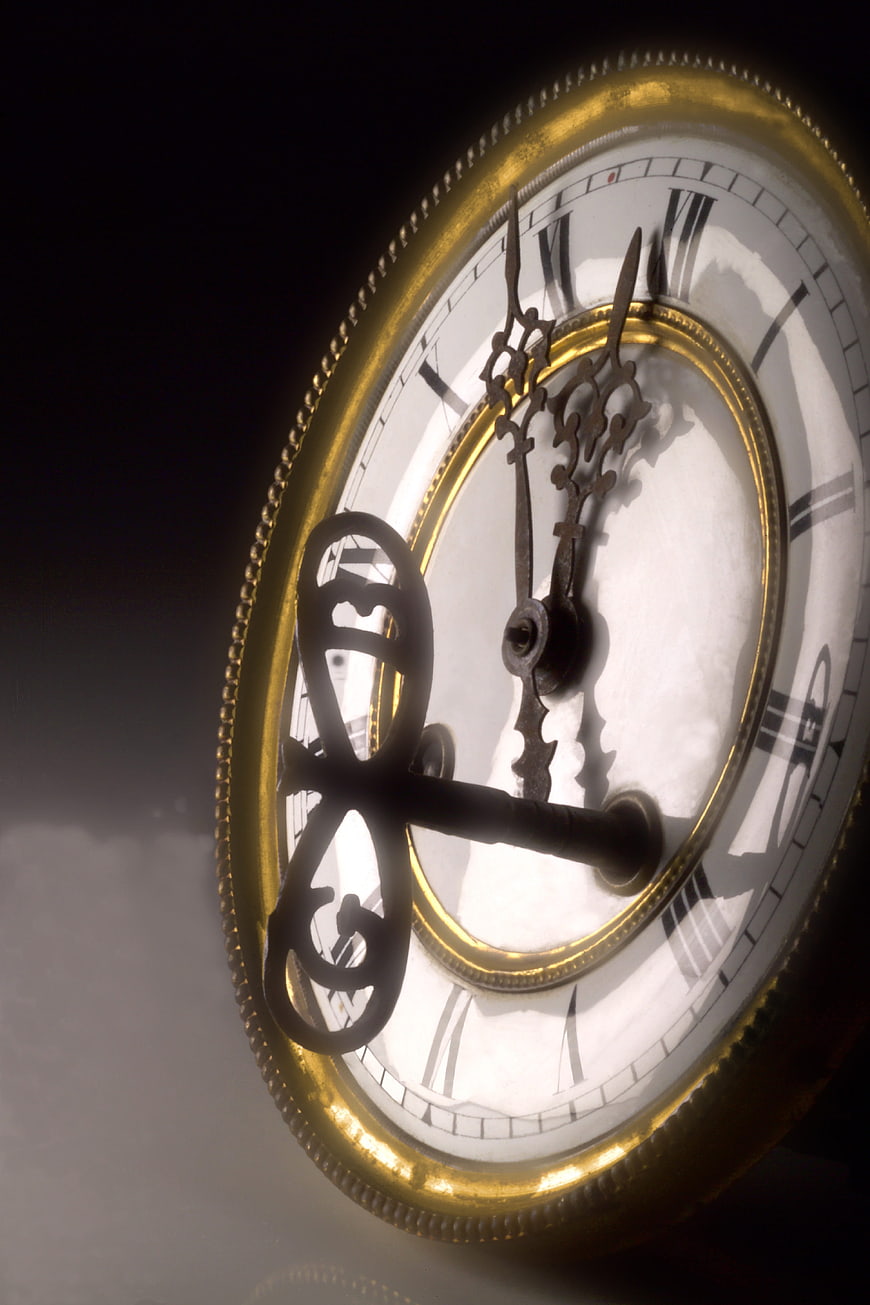 Vintage Gold Clock with Ornate Hands on Dark Background