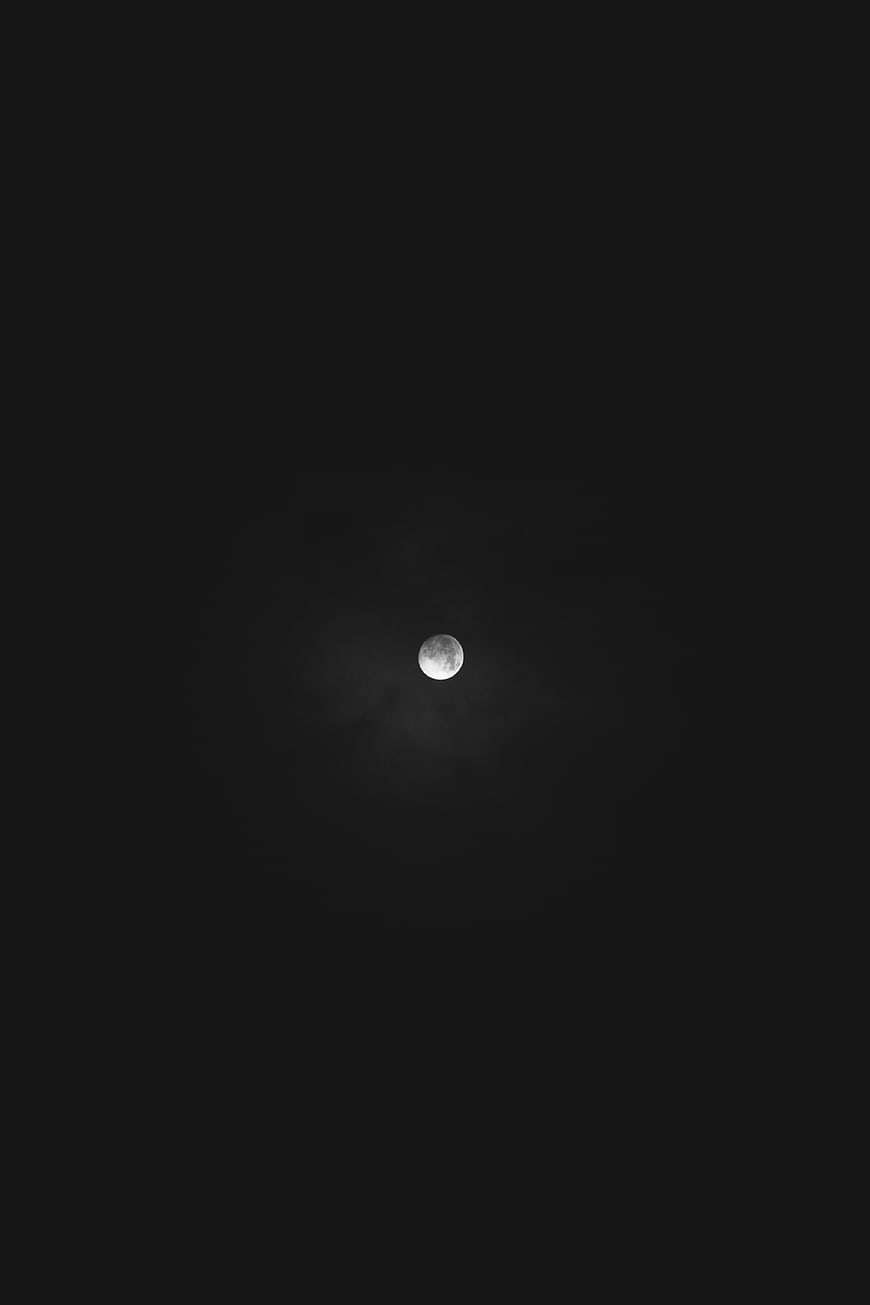 Full moon in dark night sky with subtle clouds