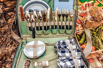 Open Picnic Hamper with Cutlery, Plates, and Fresh Vegetables