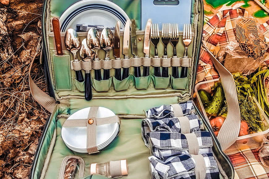 Open Picnic Hamper with Cutlery, Plates, and Fresh Vegetables