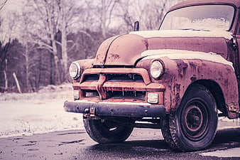Rusty vintage truck parked on snowy road in winter