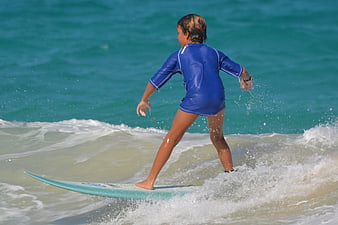 Young boy surfing on a wave in the ocean
