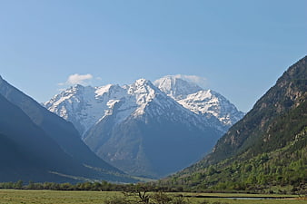 Snow-Capped Mountain Peaks in a Green Valley Landscape
