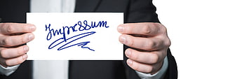 Businessman holding card with Impressum text