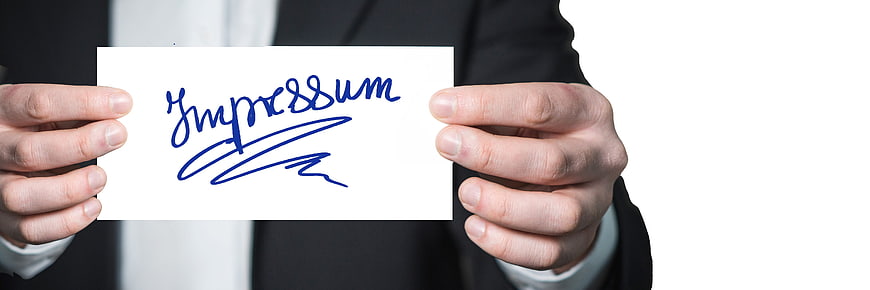 Businessman holding card with Impressum text