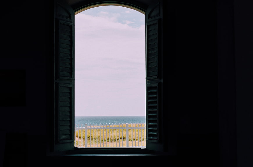 Open Window View of Ocean and White Fence