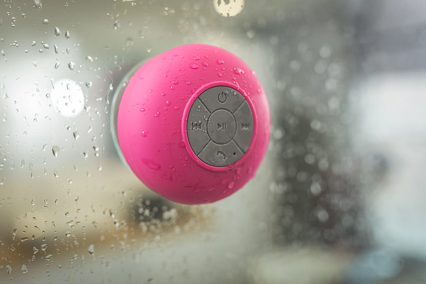 Pink Portable Bluetooth Speaker on Rainy Window